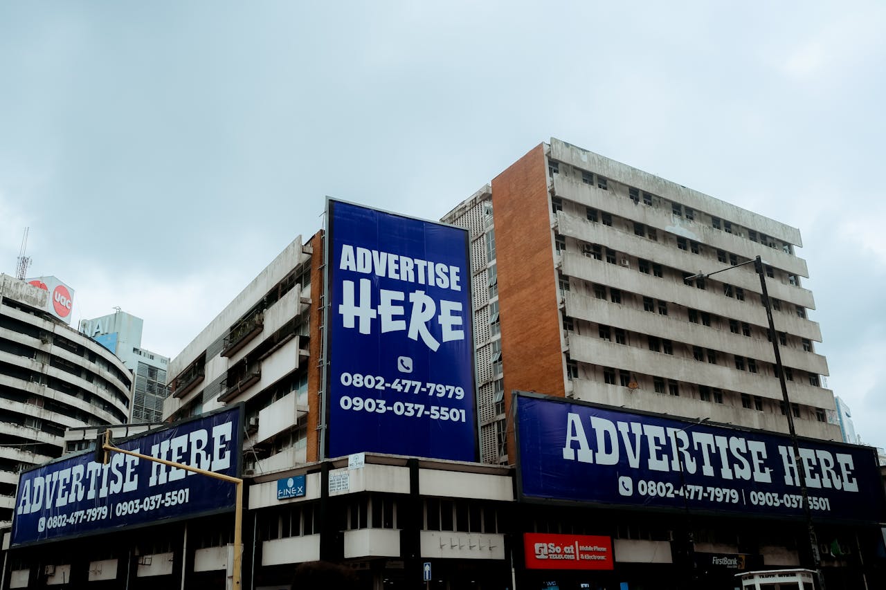 Large billboards on urban buildings displaying Advertise Here in Lagos, Nigeria.